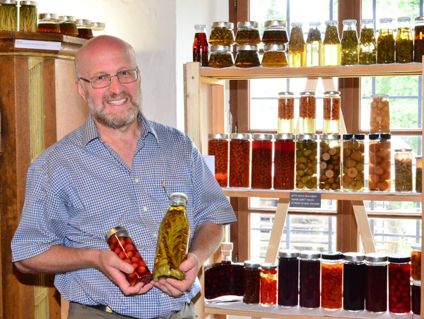 Dr. Michael Machatschek steht vor einem Regal mit Flaschen und Gläsern mit fermentierten Lebensmitteln.