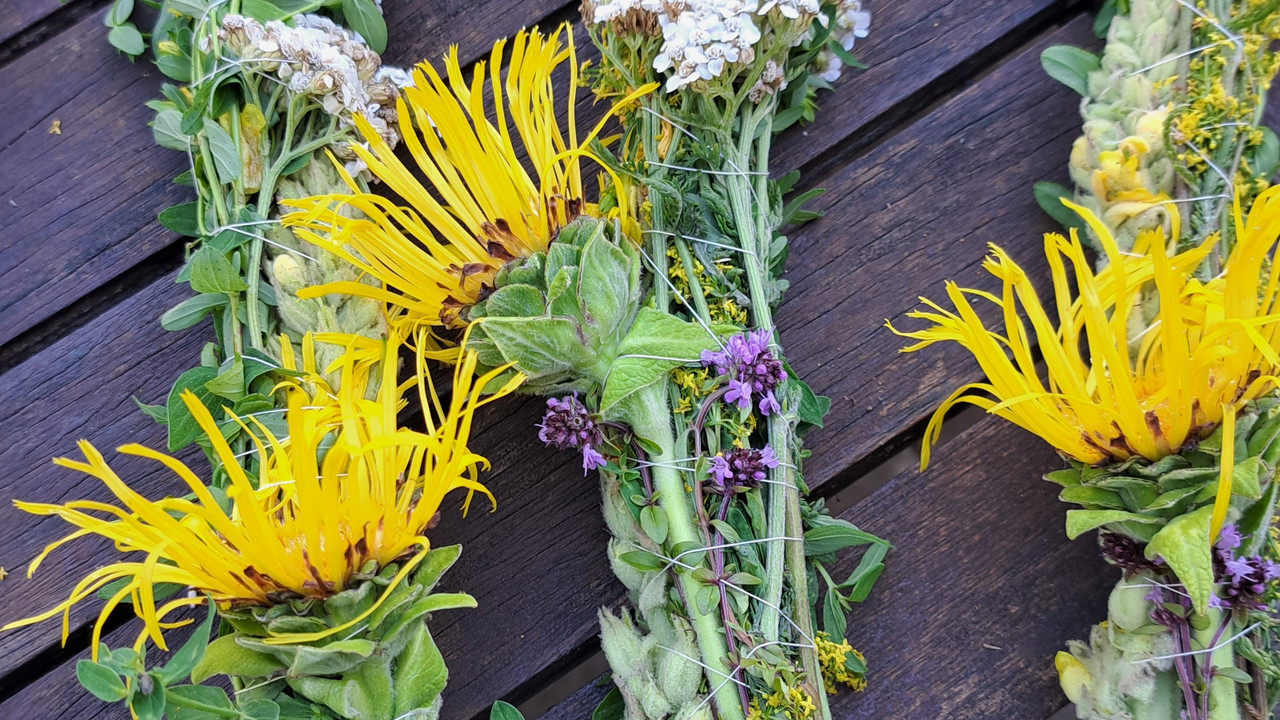 drei gebundene Bündel mit Wildblumen auf einem Tisch