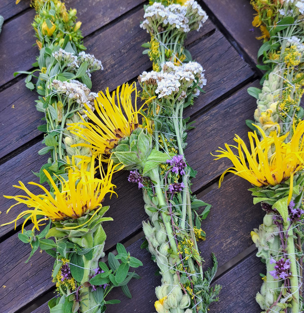 drei gebundene Bündel mit Wildblumen auf einem Tisch