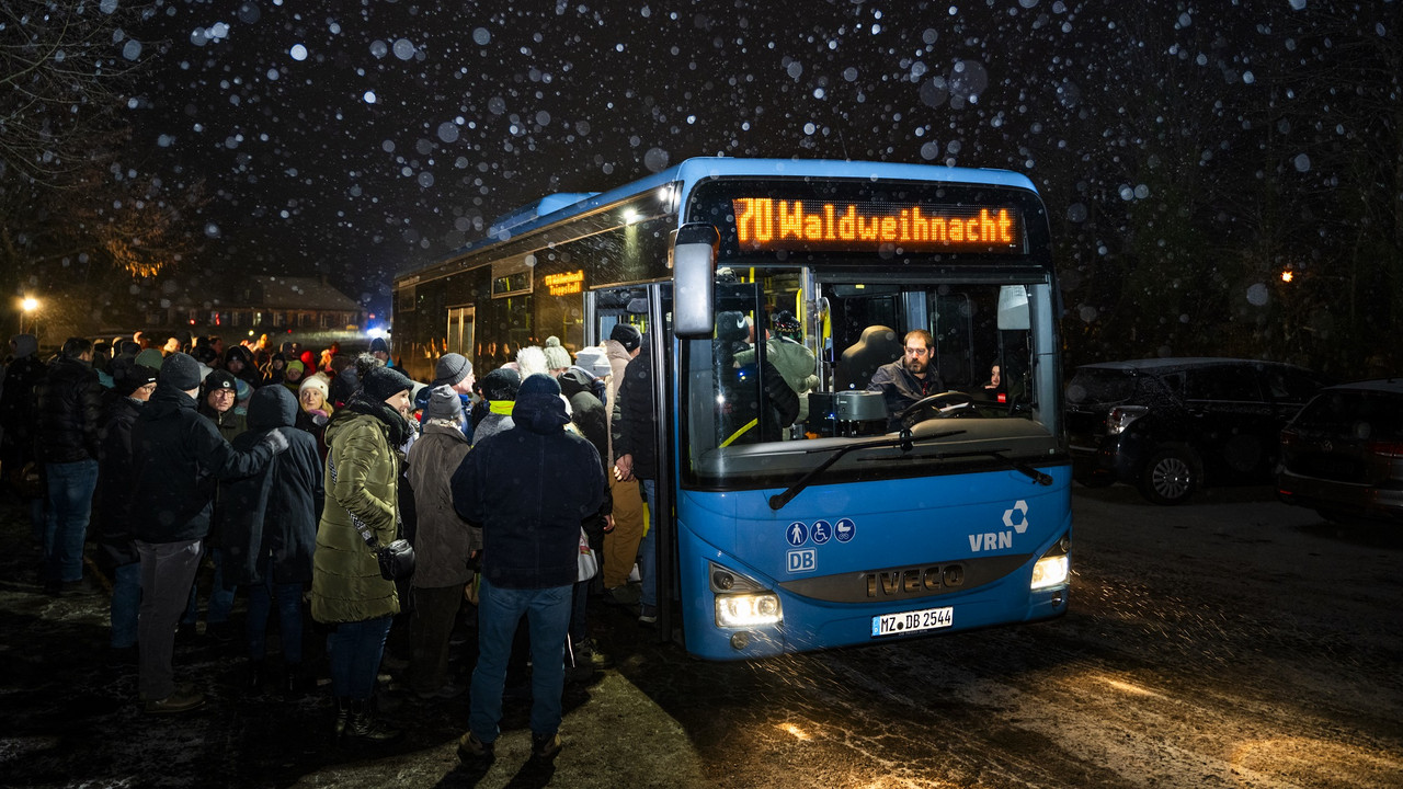 Busse bei der Romantischen Waldweihnacht Bus im Dunkeln im Schnee mit Menschen