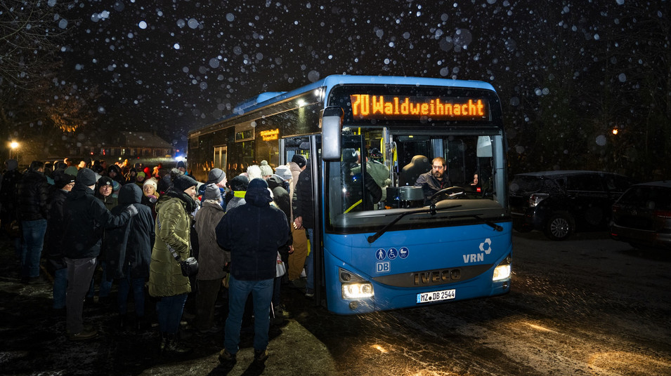 Bus im Dunkeln im Schnee mit Menschen