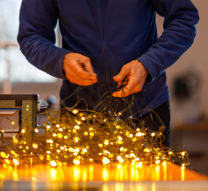 Reparaturhelfer untersucht eine Leuchtende Lichterkette