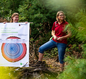 Zwei Frauen in roten Polohemden und ein Banner