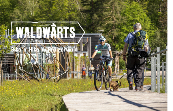 Das Bild zeigt einen Mountainbiker und Wanderer vor dem Haus der Nachhaltigkeit