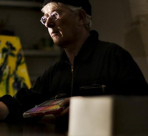 Mann in schwarzer Kleindung und Farbe malt