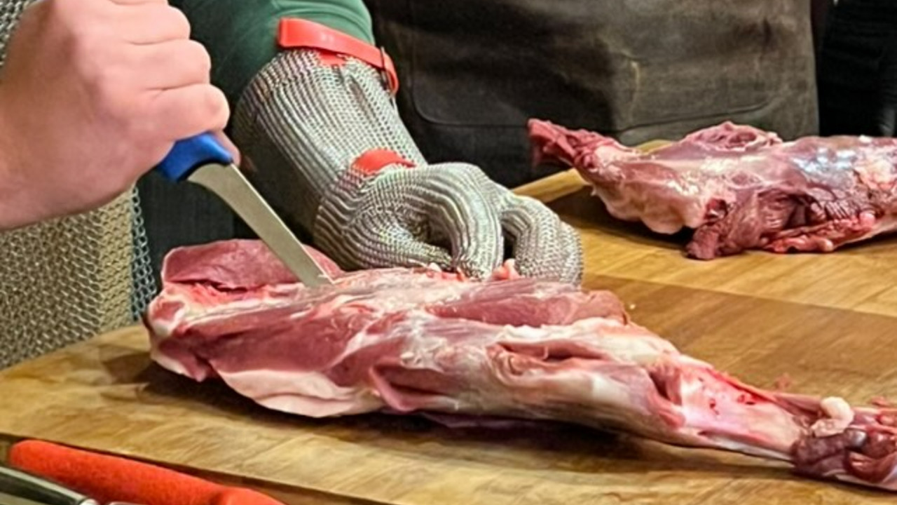 Die Teilnehmenden können bei den Wurstseminaren selbst Hand anlegen Fokus auf Fleischstück, das gerade entbeint wird