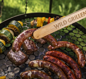 Grillzange hält Wurst über Rost