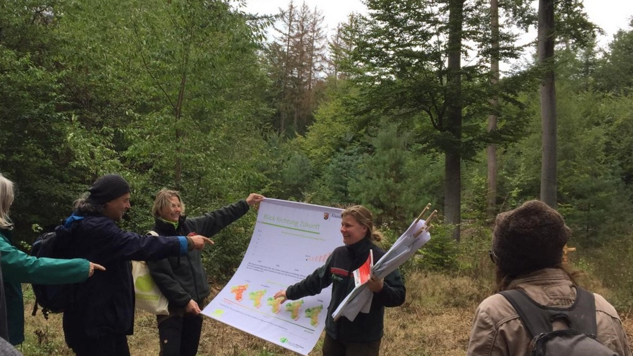 Zwei Frauen zeigen eine Grafik im Wald